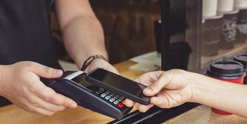 Die Zukunft des Zahlens: Jemand bezahlt via TWINT mit dem Handy an einem Kartenlesegerät.