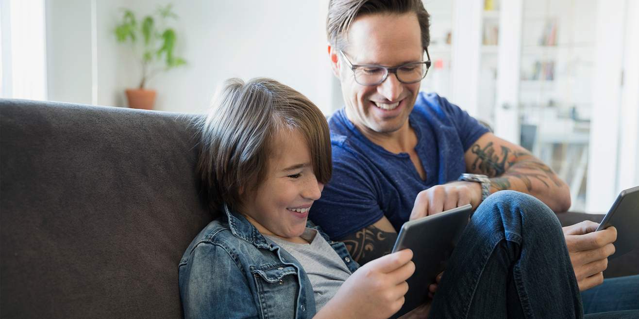 Traps on the internet: father and son together in front of a tablet. 
