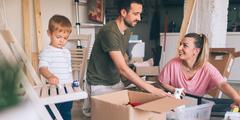 Parents avec un enfant en train de déballer les cartons d'un déménagement.
