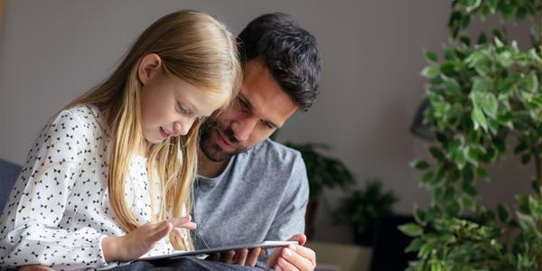 Padre e figlia al tablet apprendono tutto sul tema denaro. 